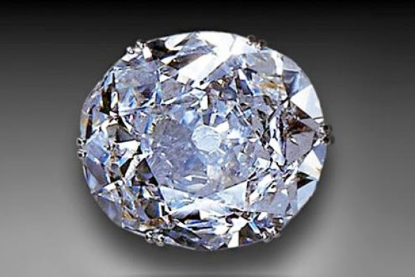 Großer runder, facettierter Diamant im Brillantschliff mit silbrig-weißem Funkeln auf grauem Hintergrund