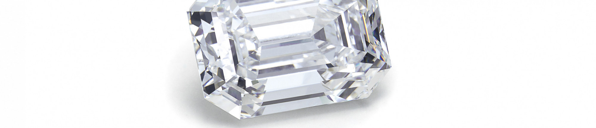 Brillanter Diamant im Smaragdschliff, lose auf weißem Hintergrund, transparent mit klaren Facetten Den Emerald Cut kennt man vor allem beim Smaragd. Bei Diamanten ist er weniger bekannt.