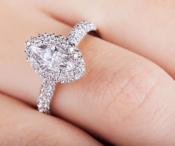Platin-Verlobungsring mit marquise-geschliffenem Diamanten, von runden Brillanten in Pavéfassung umgeben