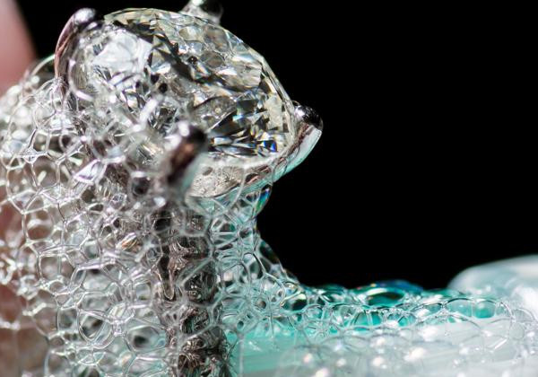 Nahaufnahme eines mit weißem Schaum und Chlorwasser bedeckten Diamantrings aus Weißgold