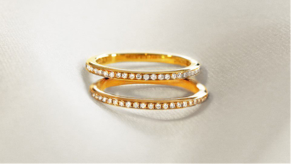 Zwei elegante Verlobungsringe aus Gold mit dünnen Bändern, die mit Diamanten aus Gelbgold verziert sind