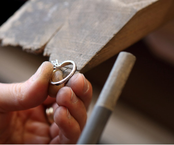Ein Handwerker bedient in einer Werkstatt eine Maschine und konzentriert sich dabei mit Präzision und Geschick auf den Prozess des Diamantschneidens