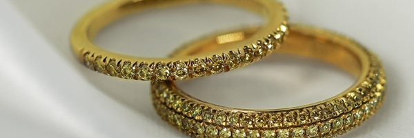 Zwei Gelbgold-Trauringe aus Diamanten auf einem Tuch