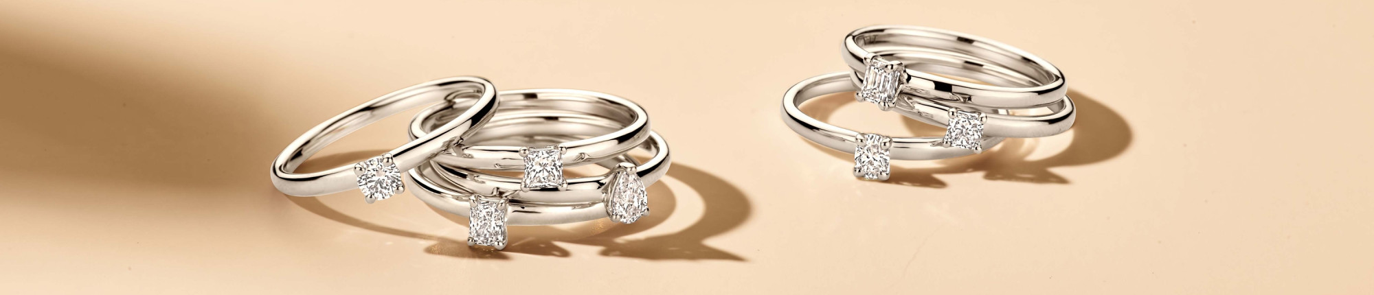 Mehrere schmale Platinringe mit Diamanten in Krappenfassung, elegant gestapelt