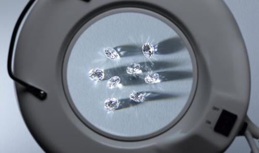 Diamanten unterschiedlicher Schliffformen unter einer Lupe