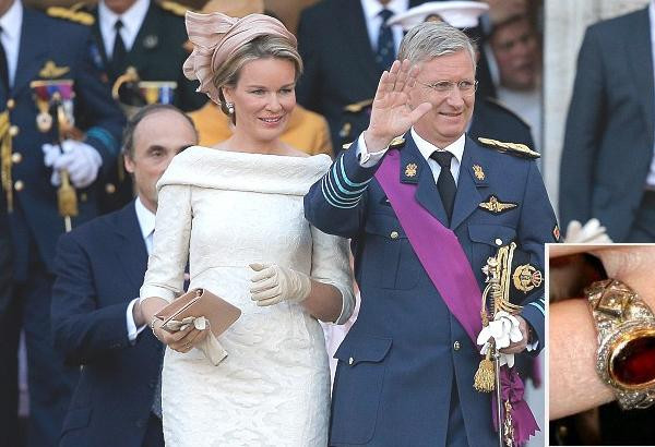 Königin Mathilde trägt einen goldenen Verlobungsring mit rotem Edelstein und Diamantbesatz am Finger.