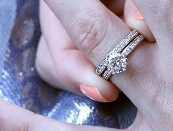 Verlobungsring und Ehering mit Diamanten an einer Hand kombiniert