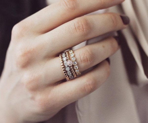 woman confidently wearing stackable rings on her ring finger in different styles and settings