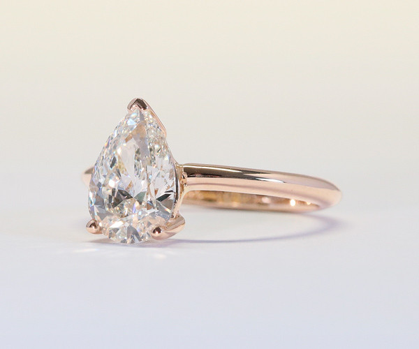 pear cut diamond ring in rose gold on white background