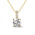 1.50 carat solitaire pendant in yellow gold with four prongs and round diamonds