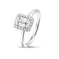 0.70 carat solitaire halo ring with an emerald cut diamond in white gold with round diamonds