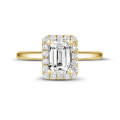 1.20 carat solitaire halo ring with an emerald cut diamond in yellow gold with round diamonds