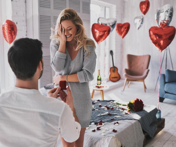 a man proposing to his wife with a double diamond engagement ring in a jewellery box, making the woman twice as happy