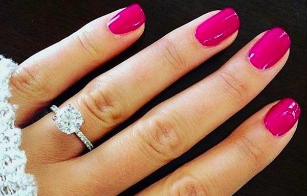 woman wearing a white gold engagement ring with fuchsia nail polish, perfectly complementing the cool tones of white gold