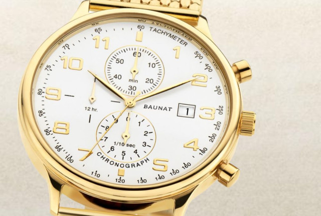 Gold-tone chronograph wristwatch with white dial, date window, and three subdials