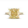 7.07ct solitaire ring in yellow gold with ‘fancy intense yellow’ cushion diamond and side stones 