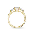 1.00 carat trilogy ring in yellow gold with an emerald cut diamond and tapered baguettes