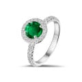 Halo solitaire ring in white gold with a round emerald and small diamonds
