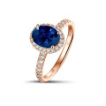 Halo solitaire ring in red gold with an oval sapphire and small diamonds