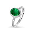 Halo solitaire ring in white gold with an oval emerald and small diamonds