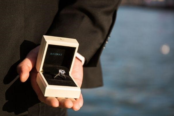 a well-dressed man showcasing a BAUNAT diamond ring with a particular carat size