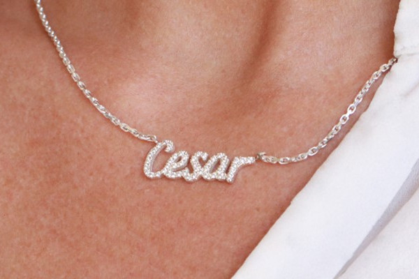 gold chain necklace with a pavé diamond name pendant spelling Cesar