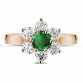 Flower ring in red gold with a round emerald and side diamonds