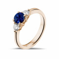 Trilogy ring in red gold with a central sapphire and 2 round diamonds