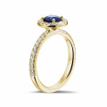Halo solitaire ring in yellow gold with a round sapphire and small diamonds