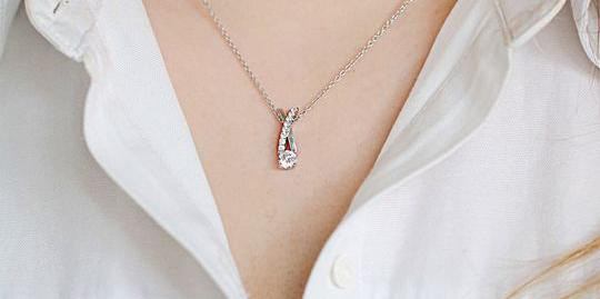Colgante de oro blanco con diamante talla pera y detalle engastado, sobre cadena fina