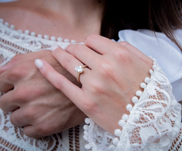Anillo de compromiso de oro rosa con diamante solitario ovalado y pavé fino en la banda