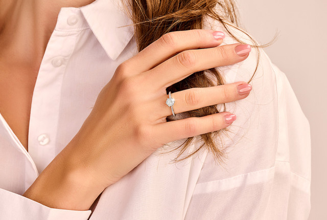 Anillo de compromiso en oro blanco con diamante solitario y brazo fino, sobre mano femenina