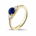 Anillo trilogía en oro amarillo con zafiro central y diamantes redondos