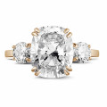 Anillo en oro rojo con un diamante de talla cojín y diamantes redondos