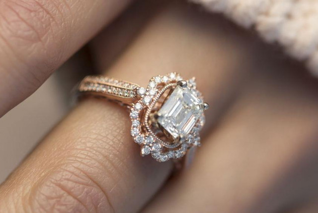 Bague de fiançailles en or rose avec diamant central taille émeraude, halo pavé de diamants