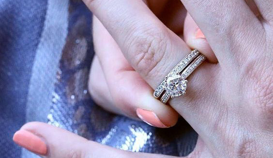 Bague de fiançailles en or blanc avec diamant rond central et pavage de petits diamants sur l’anneau