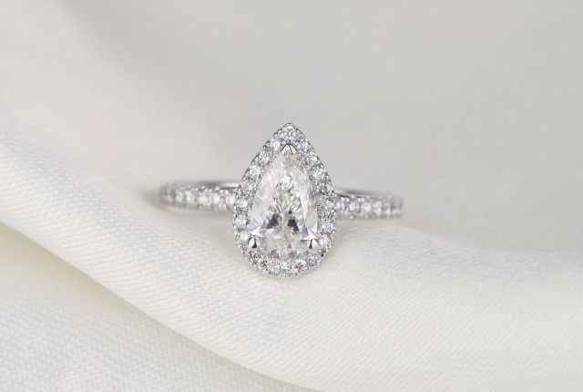 Bague en or blanc sertie d’un diamant poire central, entouré de pavage brillant