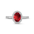 Bague solitaire de type auréole en or blanc avec un rubis ovale et diamants ronds
