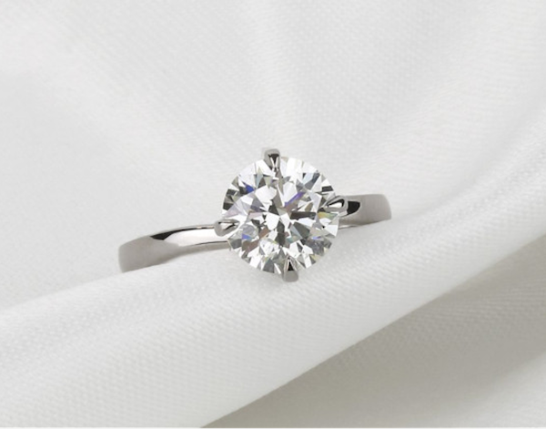 un diamant rond exposé au centre d'une bague, mettant en valeur son allure luxueuse et son savoir-faire