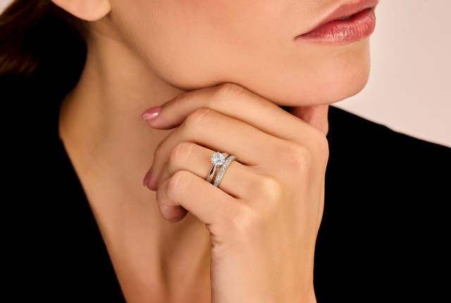 Alliance de mariage et bague de fiançailles en or blanc avec diamant rond solitaire et pavage.