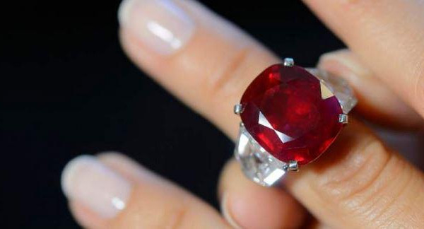 Bague en or blanc sertie d’un grand rubis ovale rouge, montée sur griffes avec diamants latéraux