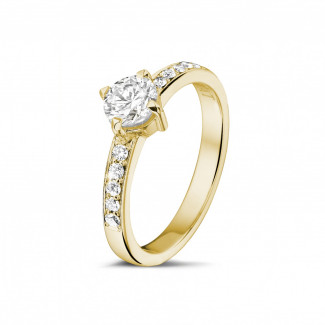Anello solitario con diamante da 0,70 carati in oro giallo con diamanti laterali