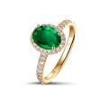 Anello solitario Halo in oro giallo con smeraldo ovale e piccoli diamanti