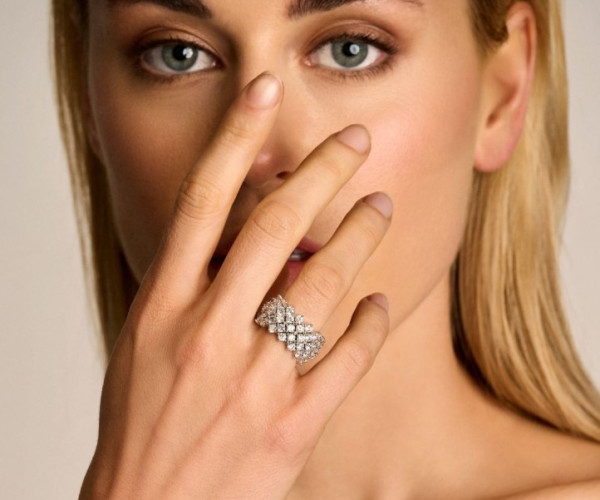 Una donna che sfoggia un anello a coda di pesce in oro bianco 18 carati adornato con diamanti scintillanti.