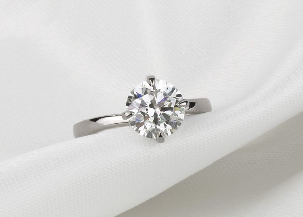 un diamante rotondo incastonato al centro di un anello, che ne esalta il fascino lussuoso e la maestria artigianale