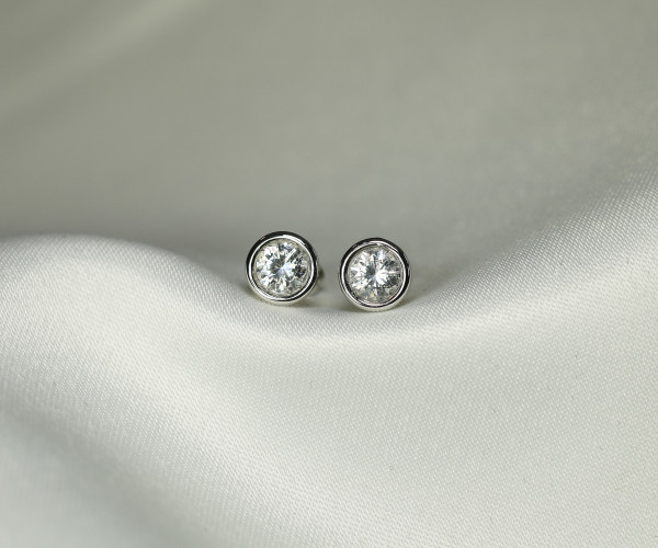 Un paio di eleganti orecchini a bottone in argento con diamanti scintillanti, che mettono in risalto un design raffinato e sofisticato.