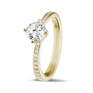 Anello solitario con diamante da 0,70 carati in oro giallo con diamanti laterali