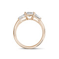 1.00 carat trilogy ring in red gold with an emerald cut diamond and tapered baguettes