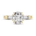 1.00 carat trilogy ring in yellow gold with oval diamond and tapered baguettes