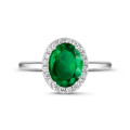 Halo ring in white gold with an oval emerald